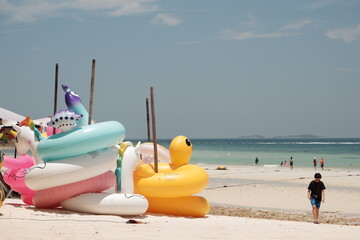 People are having fun enjoying the ocean waves on Pattaya beach in Thailand in summer.