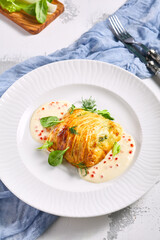 Zander Fish Baked in Dough with Caviar and Cream Sauce. Restaurant food plate on white table. Delicious baked fish meal.