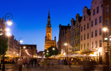 Illuminated streets of Gdansk with spire of Main Town Hall in twilight, Poland.