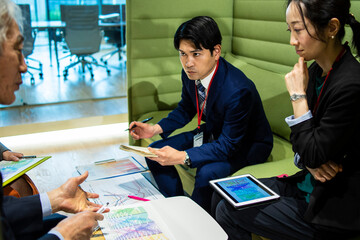 資料を眺めながら会議を行う会社員たち