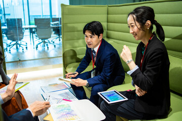 資料を眺めながら会議を行う会社員たち