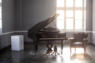 black antique grand piano in the interior with beautiful light from the window