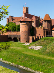 Fototapeta na wymiar Brick walls and towers of medieval Malbork Castle in sunny summer day, Poland.