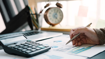 Woman accountant or banker use calculator for calculation financial report.