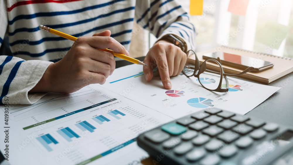 Poster close up of accountant hand holding pencil while working on calculator to calculate financial data r