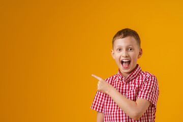 cheerful, happy child points up, copying the place for the text. A smiling, enthusiastic teenage...