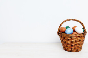 Easter eggs in a wicker basket on a Light background Copy Space