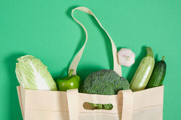 cloth shopper with vegetables on a green background