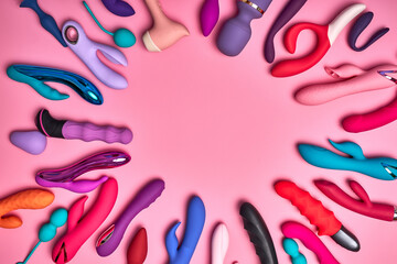 Multi-colored vibrators and silicone sex toys for adults on colourful background. Intimate sex games. Concept for sex shop.