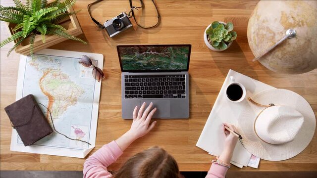 Top view of young woman with laptop planning vacation trip holiday.