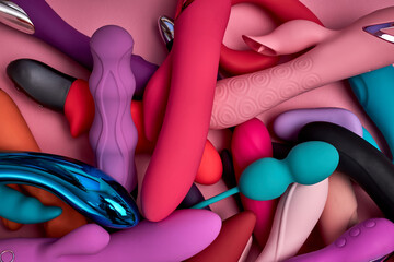bright stack of rubber sex toys, big amount of silicone dildos for women. sex shop concept. flat lay