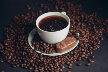 a cup of coffee and a chocolate bar on a saucer arabica beans variety drink