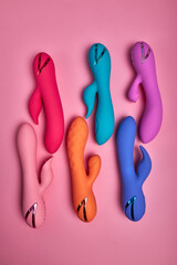 Stimulate Your Most Sensitive Area. Composition Of Colorful G-spot Vibrators Arranged On Pink Paper...