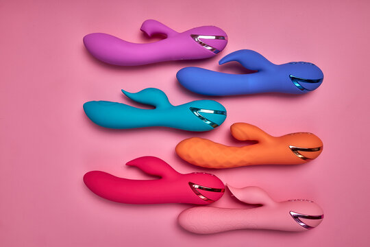 Discover sexier you. Collection of different colorful G-spot vibrators arranged on pink background. Smart gadget and masturbation device. View from above. Place for text. Flat lay. Sex shop concept.