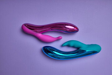 Colourful dildos. Sex toy for adult isolated on purple background. Vibrators for sex imitating...