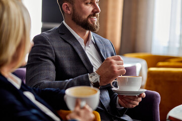businessman and businesswoman having pleasant conversation for a cup of coffee in cafe, restaurant