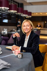 40-45 years old woman after business meeting in restaurant, smile, enjoy free time, looking at side, wearing elegant wear