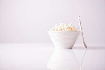 fresh Cottage Cheese In Bowl on a light background.