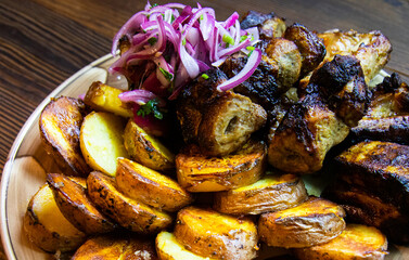 Grilled meat with fried potatoes and vegetables and onions