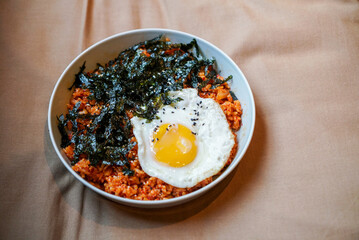 Kimchi Fried rice, a Korean traditional food. A plate of rice fried with kimchi and pork, topped with seaweed and fried egg. (Isolated)