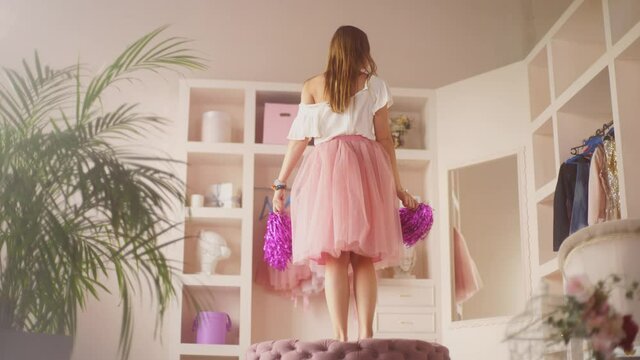 Cheerleader girl holds pompons and dances