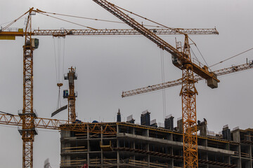 Construction site with high-rise cranes. Construction of modern apartment buildings and a new residential complex.