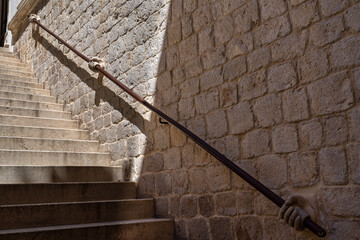 Stone hand holding stairway railing in the Rectors Palace in Dubrovnik, Croatia.