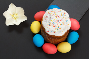 Easter cake and colored Easter eggs on black background.