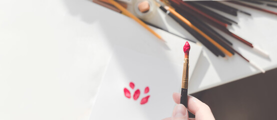 Woman painting a picture with a brush. Learning to draw at home. Autor Creating content concept