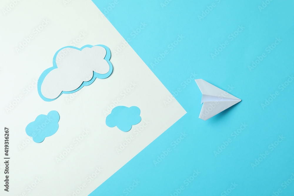 Wall mural travel concept with paper plane and clouds on two tone background