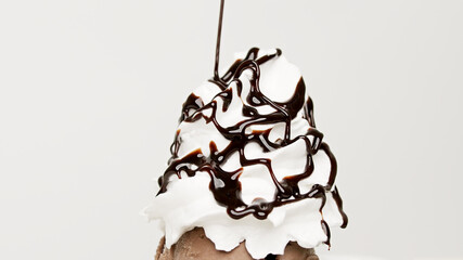 Naklejka na ściany i meble Pour chocolate sauce whipped cream on white background, Food concept Front view.