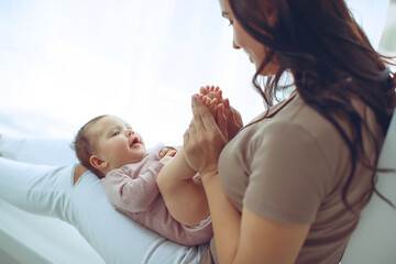 A young mother is holding her newborn baby. Mother of a nursing baby. Mother breastfeeding her baby. The family is at home. Portrait of a happy mother and child. High quality photo.