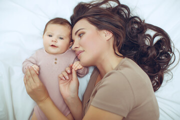 A young mother is holding her newborn baby. Mother of a nursing baby. Mother breastfeeding her...
