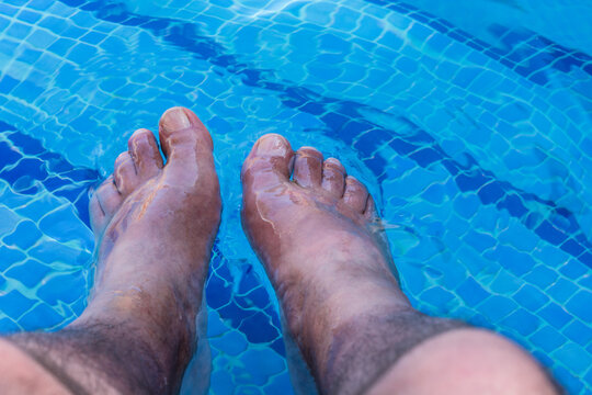 Men feet in a swimming pool