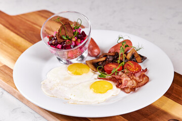 Prettily Decorated Dish On Plate, Fried Eggs Bacon, Tomato and Salad Served At Table, Flat Lay Close-up photo. Menu, Cooking, Food, Restaurant concept
