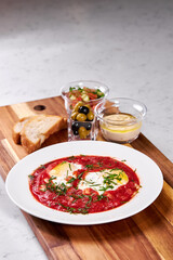 Close-up photo of dish on plate, eggs in red sauce soup beautifully served for restaurant guests. Professionally cooked meal garnish