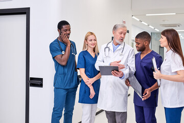 Diverse Students At Medical Practice In Hospital, Young Men And Women Adopt Experience Of Senior...
