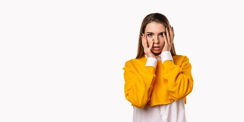 Worried, scared girl hold hands near face with open mouth, as hear something exciting, standing white background