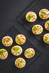 Small tarte flambee or mini pizza with onion, bacon and arugula