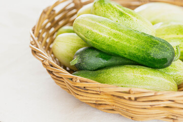 Close up group of fresh organic cucumber or zucchini in wood basket on white table. Cucumber or zucchini is crunchy vegetable which have sweet taste and crunchy for salad and cooking.