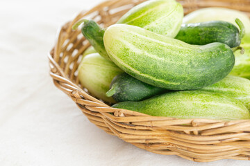 Close up group of fresh organic cucumber or zucchini in wood basket on white table. Cucumber or zucchini is crunchy vegetable which have sweet taste and crunchy for salad and cooking.