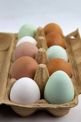 Green, brown and white eggs in a egg box