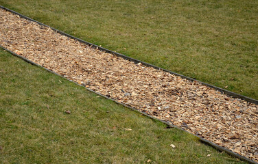 park path in the outdoor fitness training center. The soft surface of the narrow jogging path is...