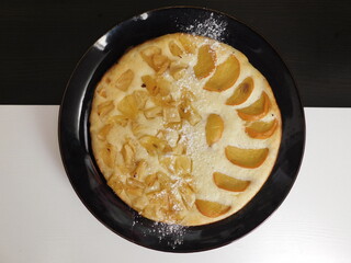 Home made apple cake in the black plate served on table.