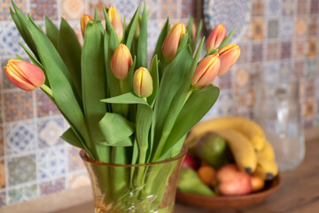bouquet of tulips and fruits in kitchen