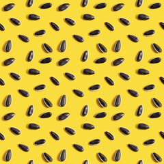Black sunflower seeds on yellow background. Raw whole grains, organic healthy food