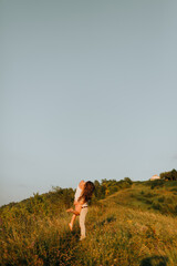 couple hugs in the grass against the blue sky