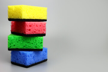 stack of colored sponges for washing dishes or cleaning the house - obrazy, fototapety, plakaty