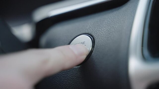Engine start stop button from a modern car interior. Start car engine by pushing a button. Flashing start stop engine button in a sports car close up