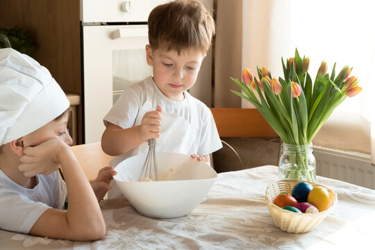 two seriouse brothers boys cook and knead easter pie dough in kitchen